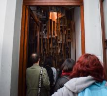 Foto. Cinco estudiantes miran hacia arriba. Contra el techo de la habitación los carteles de las personas detenidas desaparecidas que llevan sus familiares a las marchas del 20 de mayo.